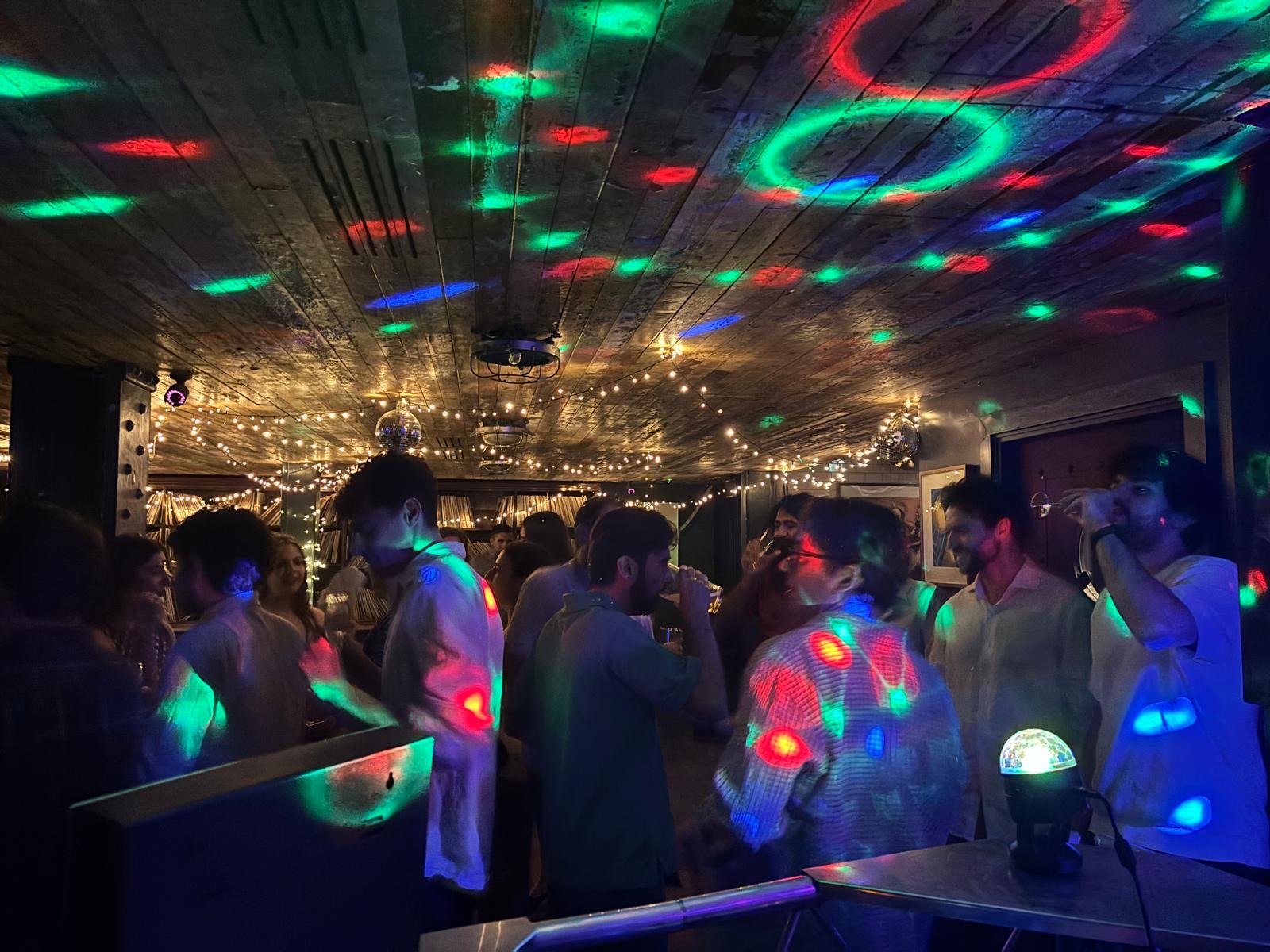 Packed dancefloor under disco lighting